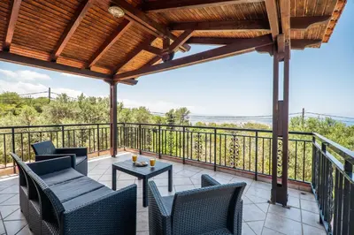 a patio with chairs and a table on a balcony at Villa Silva, Garden & Sea View, 3 BR, -10 min drive from center in Chania Town