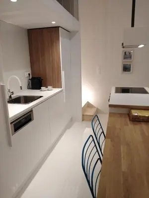 a kitchen with white counters and chairs and a sink at Fourteen All Seasons House in Chania Town