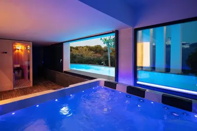 a large swimming pool in a house with two windows at Villa Alveo Del Mare in Chania Town