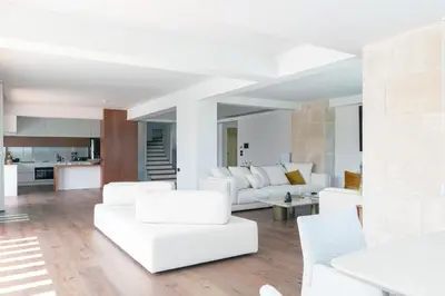 a living room with white furniture and a kitchen at Villa Alveo Del Mare in Chania Town
