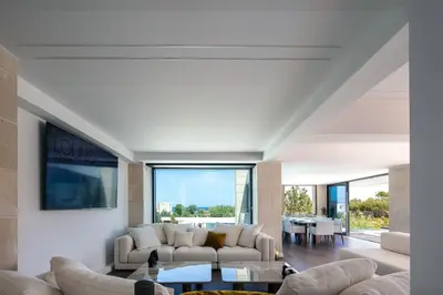 a living room with white furniture and a large window at Villa Alveo Del Mare in Chania Town