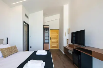 a bedroom with a bed and a tv on a wall at Villa Alveo Del Mare in Chania Town