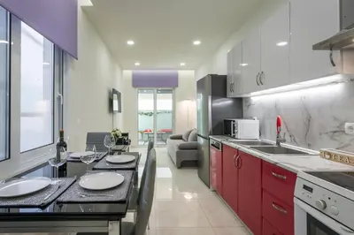 a kitchen with red cabinets and a counter top at Luxury Pearl, steps to the beach in Chania Town