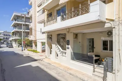 a white building with a balcony on a street at Luxury Pearl, steps to the beach in Chania Town