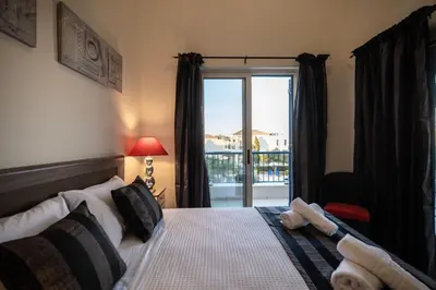 a bedroom with a bed with a view of a balcony at Villa Rodo in Pírgos Psilonérou