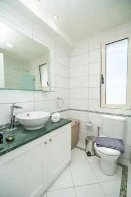 a white bathroom with a sink and a toilet at Villa Rodo in Pírgos Psilonérou