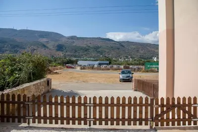 a car parked in a parking lot with a fence at Peris #1 - Souda in Souda