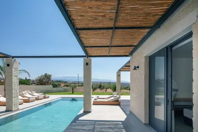 a house with a swimming pool and a patio at Ikritis Villas in Chorafakia