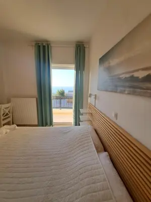 a bedroom with a bed and a large window at Ocean View in Chania Town