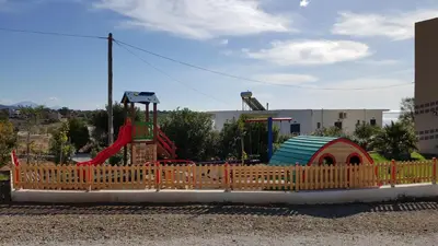 a wooden fence in front of a playground at Kritamos Beach Apartments in Frangokastello