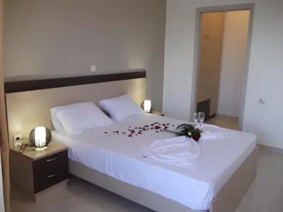 a bedroom with a bed with a flower arrangement on it at Kritamos Beach Apartments in Frangokastello