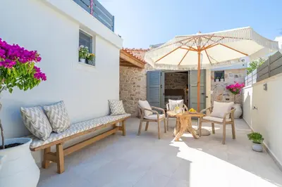 a patio with a table and chairs and an umbrella at The Violin House in Chania Town