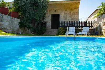 two white chairs sitting in a swimming pool at VILLA MICHAELA in Gramvousá