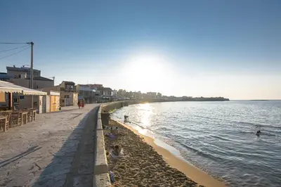 a beach with people swimming in the water at PLUS 2! in Chania Town