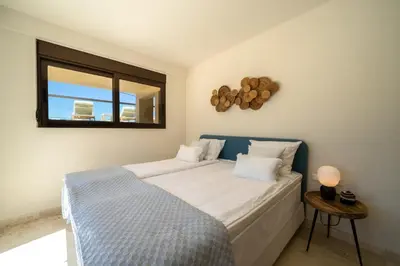 a bedroom with a bed and a mirror and a window at Villa Poseidon One - Sunset & Sea Front Villa in Chorafakia
