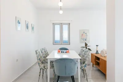 a dining room with a white table and chairs at Vista Residence in Chania Town