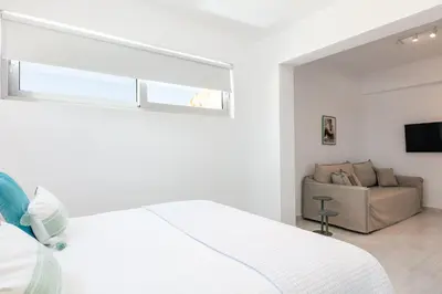 a white bedroom with a bed and a couch at Vista Residence in Chania Town