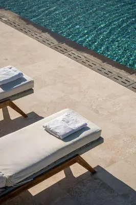 two beds sitting next to a swimming pool at Magnifique villa avec piscine au bord de mer in Chorafakia