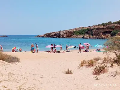 a group of people on a beach with umbrellas at Solis Occasum in Aghii Apostoli