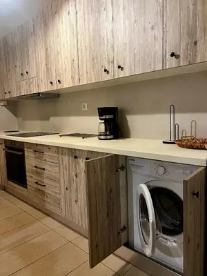 a kitchen with a washing machine under a counter at Solis Occasum in Aghii Apostoli