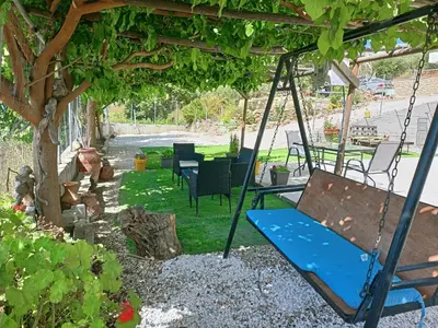 a swing in a garden with a tree at Amazing View in Kissamos