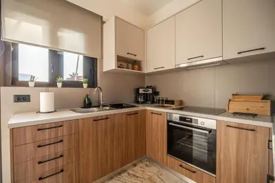a kitchen with wooden cabinets and a stove top oven at Cretan Sea View Apt 8mins to beach,old town, city in Chania Town