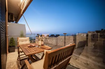 a table and chairs on a balcony with a view of the ocean at Cretan Sea View Apt 8mins to beach,old town, city in Chania Town