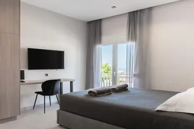 a bedroom with a bed and a desk and a television at Yiannis Deluxe Apartment in Chania Town