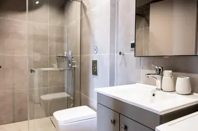 a bathroom with a shower and a sink and a toilet at Yiannis Deluxe Apartment in Chania Town