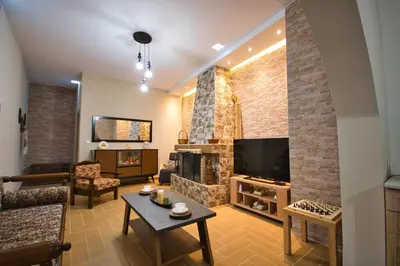 a living room with a couch and a tv at West Crete House in Kámbos