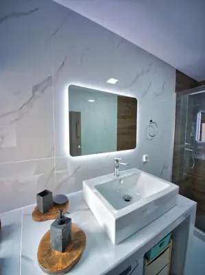 a white bathroom with a sink and a mirror at West Crete House in Kámbos