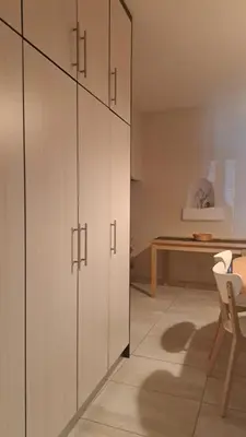 a kitchen with white cabinets and a table at Orea Kaliva in Sfinárion