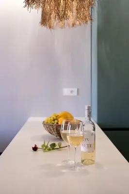a glass of white wine next to a basket of fruit at Chania Central Apartment in Chania Town