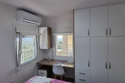 a bedroom with a desk and a bed and two windows at MAGIC VIEW APARTMENT in Chania Town