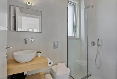 a bathroom with a white sink and a shower at Annassa Experience Suites 2' walk from Almyrida Beach in Almirida
