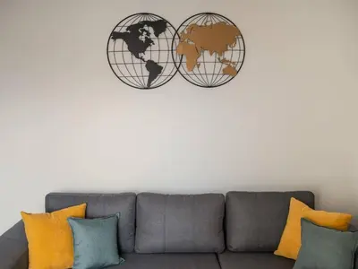 a living room with a couch and two globe clocks on the wall at NEFELI APARTMENT CHANIA in Chania Town