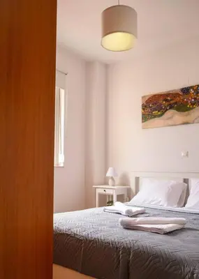 a bedroom with a bed and a painting on the wall at NEFELI APARTMENT CHANIA in Chania Town