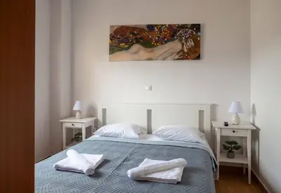 a bedroom with a bed with two towels on it at NEFELI APARTMENT CHANIA in Chania Town