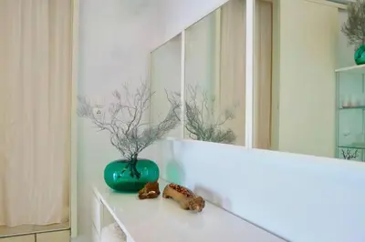 a green vase sitting on a counter in front of a mirror at Elpida Seafront Paradise apartment in Crete in Chania Town