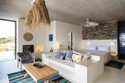 a living room with a bed and a table at Akra Grammeno Beachfront Villas in Palaiochóra