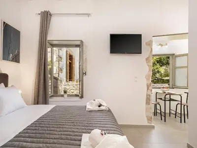 a bedroom with a bed and a table with chairs at Vaggelis house in Chania Town