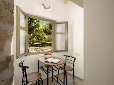 a small table and chairs in a room with a window at Vaggelis house in Chania Town