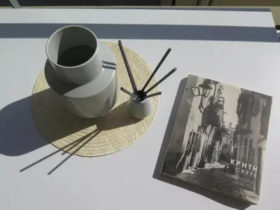 a cup of coffee and a book on a table at Alendra's City Center Studio in Chania Town