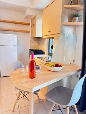 a kitchen with a wooden table with two wine glasses at Alendra's City Center Studio in Chania Town