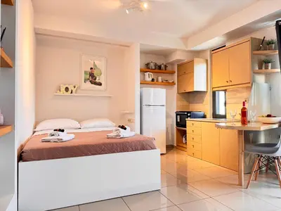 a bedroom with a bed and a small kitchen at Alendra's City Center Studio in Chania Town