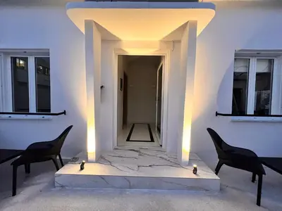 a room with two chairs and a white wall at Perla Coco Jacuzzi Suites in Chania Town