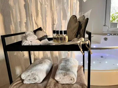 a towel rack with towels and a bath tub at Perla Coco Jacuzzi Suites in Chania Town