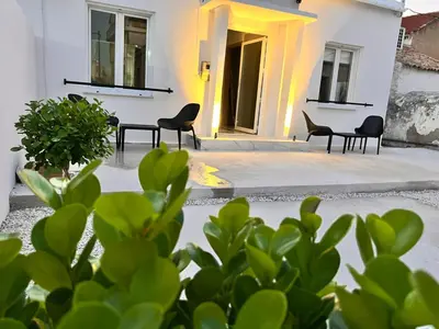a patio with chairs and plants in front of a building at Perla Coco Jacuzzi Suites in Chania Town