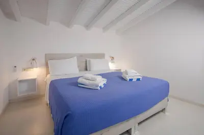 a bedroom with a blue bed with towels on it at Rose of Crete in Plataniás