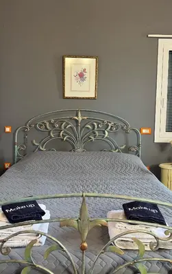 a bed with a metal frame with two towels on it at Pink House in Palaiochóra
